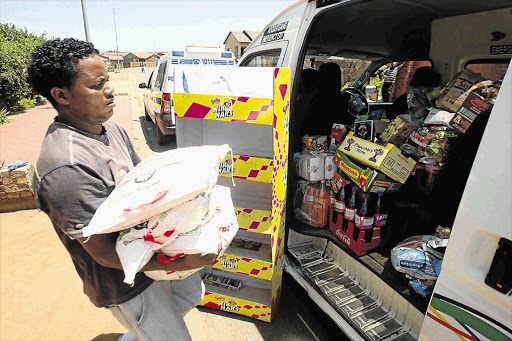 HEAVY BURDEN: A shopkeeper in Soweto loads stock into a minibus in an attempt to escape marauding mobs of looters attacking shops owned by foreigners, apparently in retaliation for the fatal shooting of a 14-year-old boy, Siphiwe Mahori, on Monday night