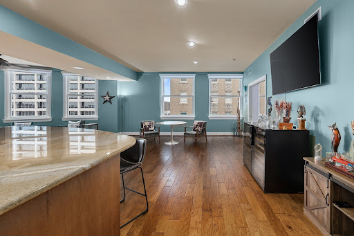 Living room with kitchen island and large screen - Luxury property for sale in Fort Worth, 2 bedrooms