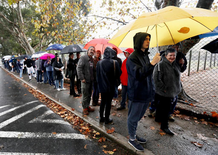 A lengthy queue formed in the rain outside the polling station at Claremont Primary School in Cape Town.