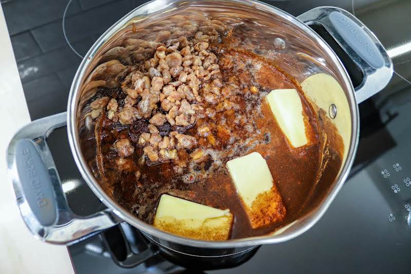 Sugar, Cinnamon, Cloves, Water, Coffee, Raisins, Dates, And Butter In A Saucepan.