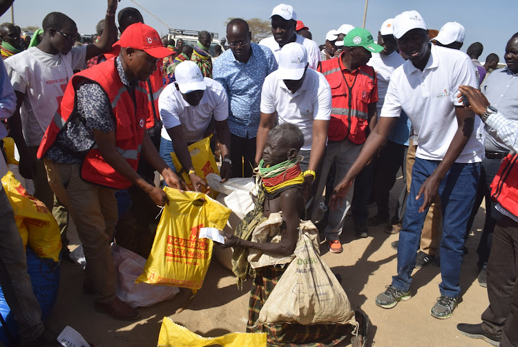 Governors Jeremiah Lomorukai (Turkana) and Jonathan Bii (Uasin Gishu), Kenya Red Cross and Save A Life Initiative team distribute relief food to hunger-stricken families in Kerio Delta ward, Turkana Central.