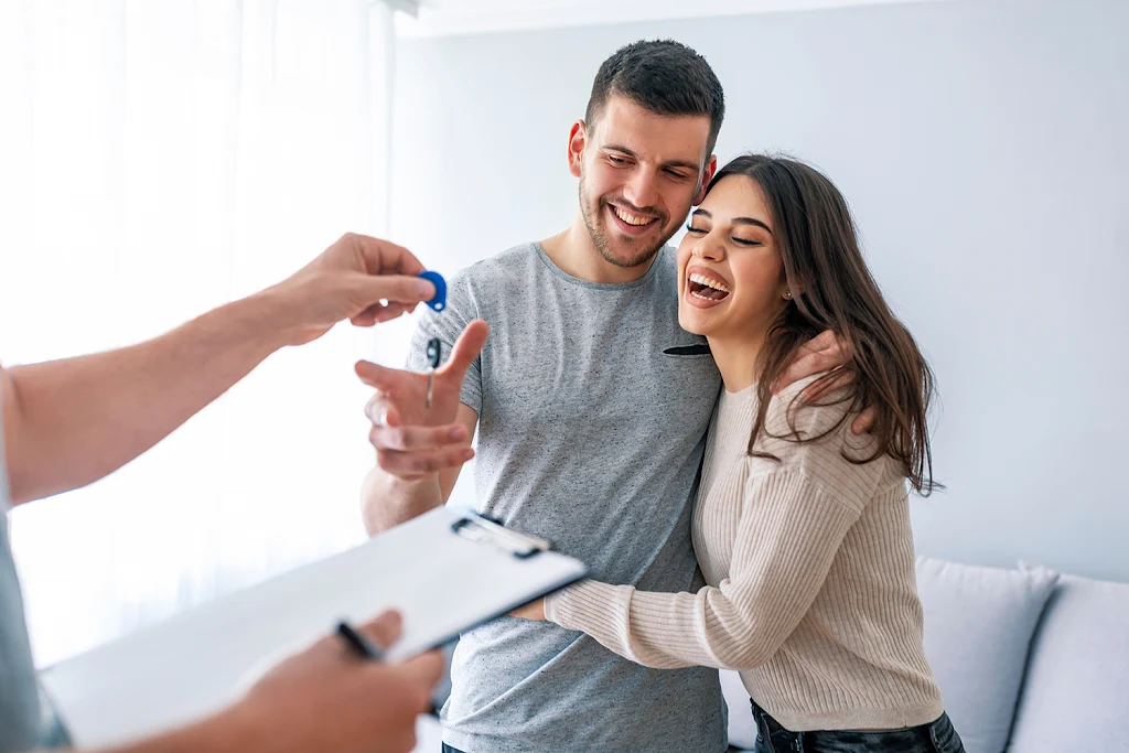 Couple receiving keys to apartment