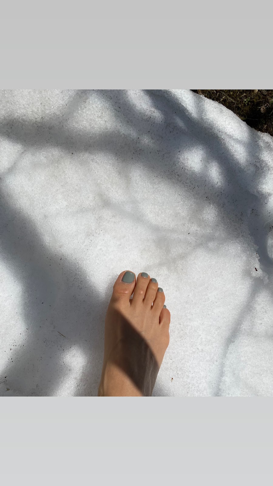 Woman's bare foot on snow.