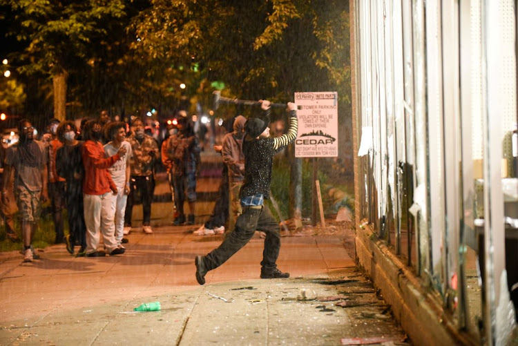 A protester vandalises an O'Reilly's near the Minneapolis Police third precinct, where demonstrators gathered after a white police officer was caught on video pressing his knee into the neck of African-American man George Floyd, who later died at a hospital, in Minneapolis, Minnesota, US, on May 27 2020.