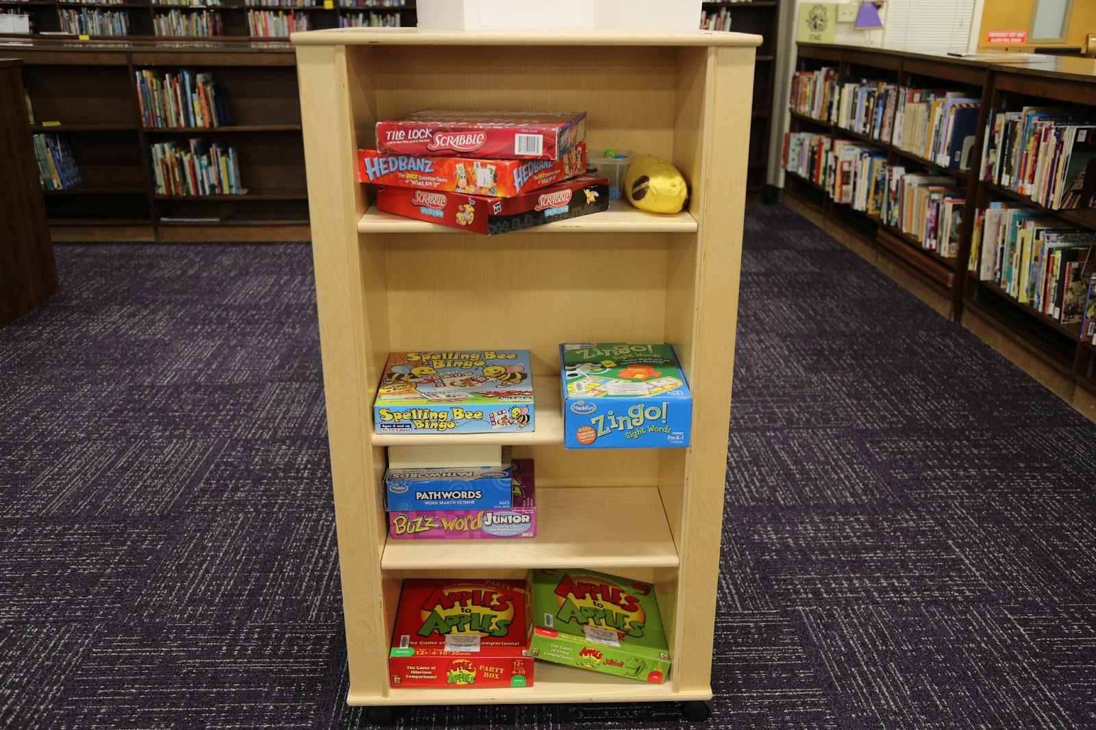 photo of a vertical shelf in the middle of the ETMC with board games, including Scrabble, Bananagrams, Apples to Apples, and Headbanz