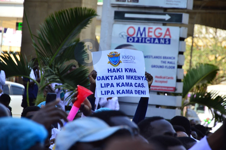 Doctors carry placards during demonstrations in Nairobi on March 22, 2024.b