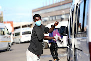 A man washes a taxi wearing a taxi in Lindelani. 