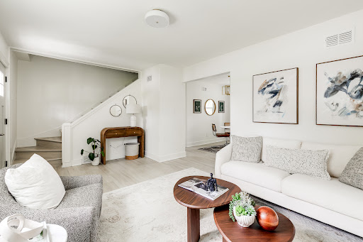 Modern living room with staircase and white sofa in this luxury house for sale in Tuckahoe ($399,000)