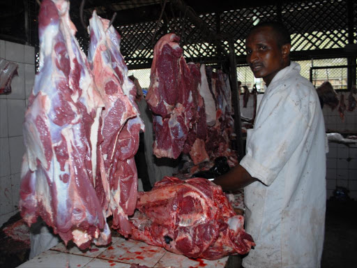 A butchery attendant prepares meat for sale