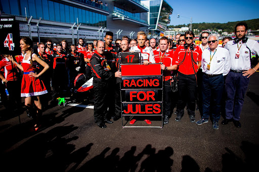 Max Chilton of Great Britain and his team of Marussia along with the FIA Race Director Charlie Whiting (second row) pose for a picture in support of their injured driver Jules Bianchi prior to the Russian Formula One Grand Prix at Sochi on October 12, 2014.