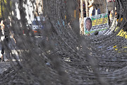 Barbed wire separates supporters of ANC Youth League president Julius Malema and Luthuli House as police redoubled their efforts to keep order in the Johannesburg city centre yesterday Picture: HALDEN KROG