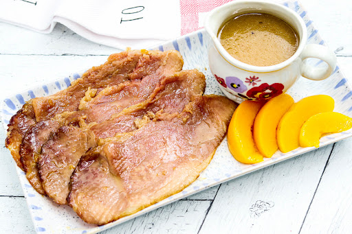 Slices of Ham With Peachy Brown Sugar Dijon Glaze on a platter.