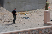 An Israeli policeman inspects the site of a rocket explosion in the Israeli Red Sea resort of Eilat April 17 2013. A Salafi jihadist group claimed responsibility for firing what it said were Grad rockets at Eilat, causing no damage or casualties.
