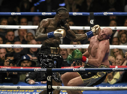 Deontay Wilder lands a left hook and knocks down Tyson Fury in the 12th round of their WBC title bout.