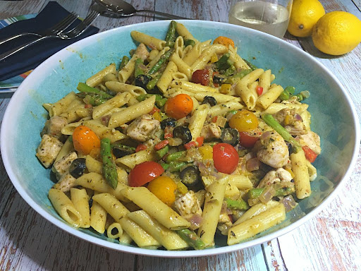 A gorgeous pasta dish made with chicken, fresh vegetables, pesto and seasonings.