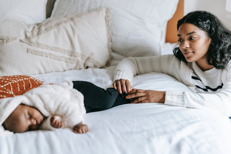 A boy sleeps under the watchful eye of his mother