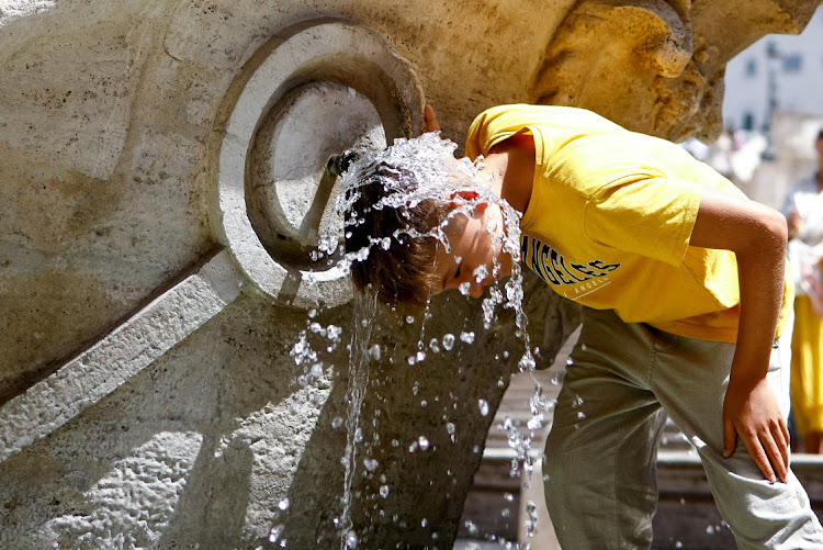 A boy cools off at Fontana della Barcaccia at the Spanish Steps in Rome on July 17 2023.