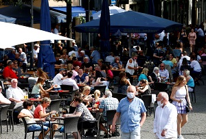 People sit at the terraces of beer gardens and restaurants, as the spread of the coronavirus disease (Covid-19) continues, in Cologne, Germany.