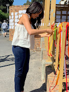 The duchess visited the Cape Town post office where 19-year-old UCT student Uyinene Mrwetyana was raped and murdered last month. It's said Meghan had been following the tragic story closely. She tied a yellow ribbon to the railing as a tribute. It carried the message, 