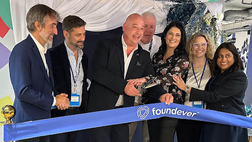 Alderman James Vos (middle) cuts the ribbon to officially welcome BPO company Foundever.