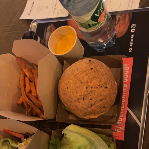 Side salad with carrot, pomegranate seeds, tomato, lettuce and more, a lettuce wrapped cheeseburger, sweet potato fries and for my partner a normal(gluten) cheeseburger