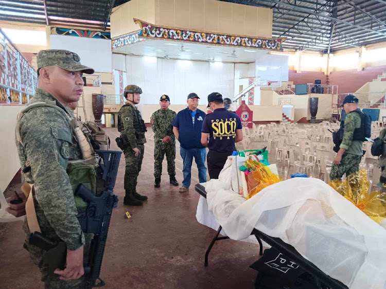 Lanao Del Sur Governor Mamintal Adiong Jr. stands among law enforcement officers as they investigate the scene of an explosion that occurred during a Catholic Mass in a gymnasium at Mindanao State University in Marawi, Philippines, December 3, 2023.