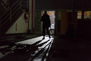 A police officer searches a looted warehouse looking for suspects during the Jeppestown attacks on Sunday night.