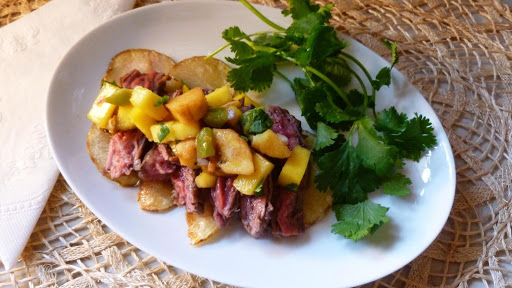 Mango and plantain salsa-topped garlic butter tenderloin steak strips, served over crispy potato nachos! It is layers of deliciousness!