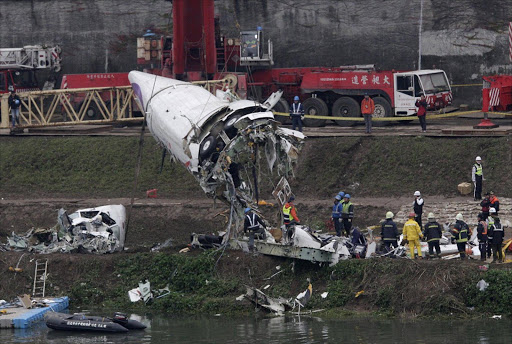 Emergency teams remove pieces of wreckage at the site of the crashed TransAsia Airways plane Flight GE235 in New Taipei City. Picture Credit: Reuters