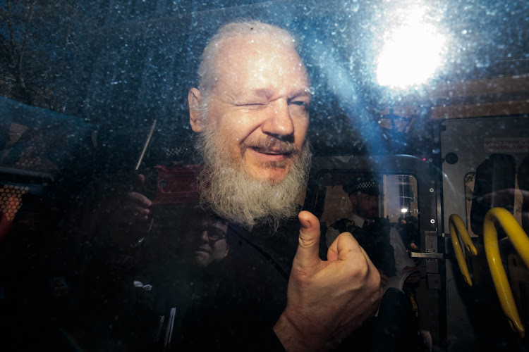 Julian Assange gestures to the media from a police vehicle on his arrival at Westminster Magistrates court on April 11, 2019 in London. Picture: JACK TAYLOR/GERRY IMAGES