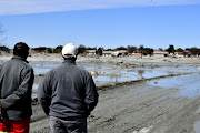 Jagersfontein residents look at the damage caused by the mine's tailings dam wall collapse.