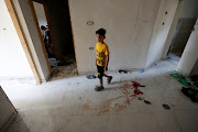 A boy walks next to blood at the scene where Israeli forces killed two Palestinians in a raid on May 6, 2023, according to the Israeli military.