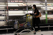A shopper walks past near-empty shelves at a supermarket in Beirut, Lebanon, on March 16 2021. 