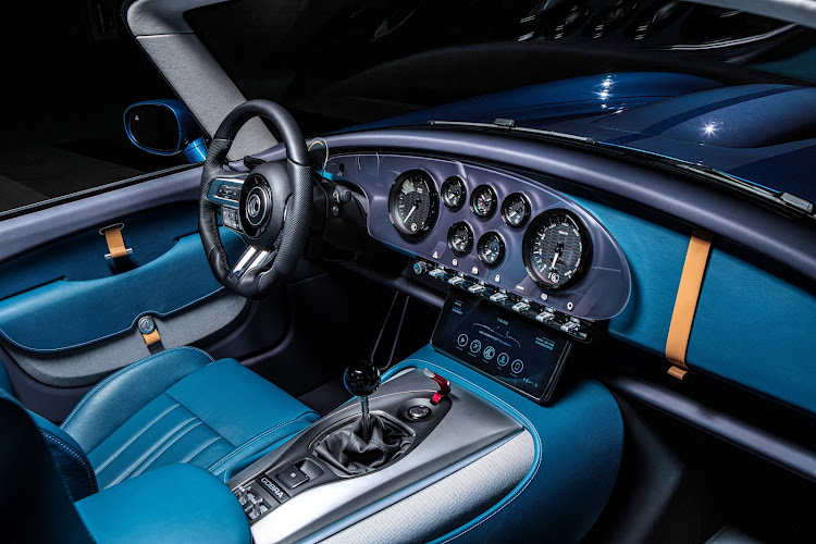 The cabin blends old-school analogue gauges with a modern touchscreen infotainment system.