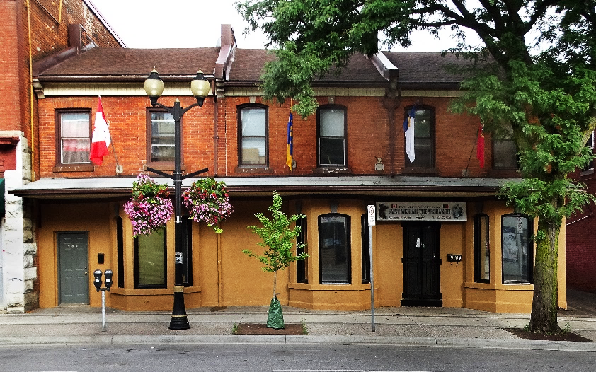 A person walking down a street in front of a brick building

Description automatically generated