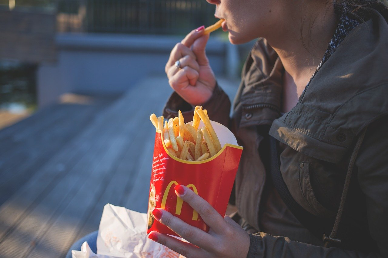 women eating fast food fries

