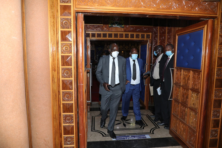 IEBC chairman Wafula Chebukati chats with Tharaka MP George Murungara leaving the Senate chambers after presenting his views on BBI Bill during public participation on March 17.