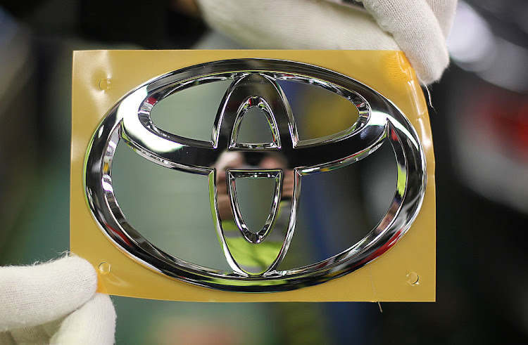 An employee displays a Toyota badge at the company's factory in Burnaston, Derbyshire.