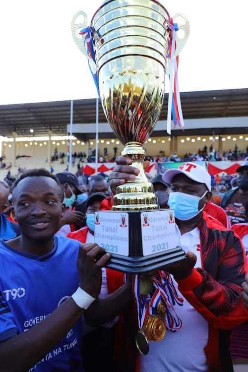 Narok Governor Samuel Tunai presents trophy Total Spurs players after winning Governor Tunai Premier Cup at William Ole Ntimama Stadium