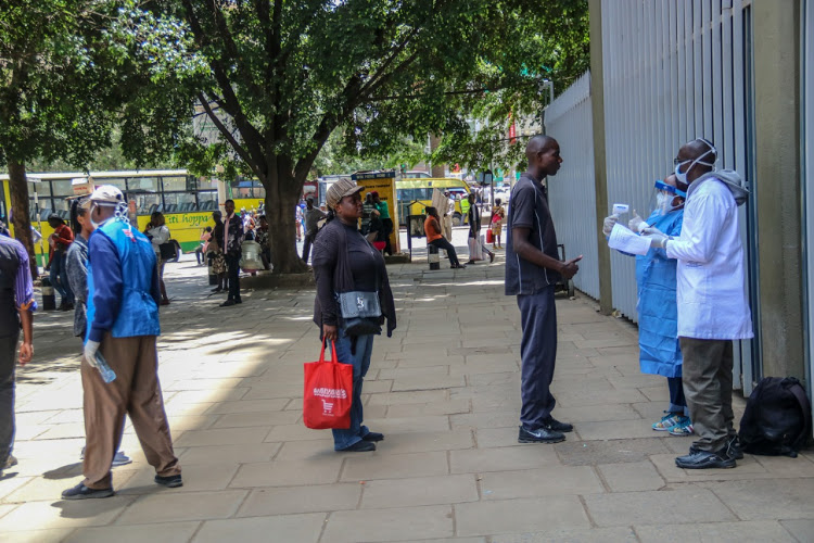 Nairobi City residents line up at the Kencom bus station for coronavirus screening on March 22, 2020.