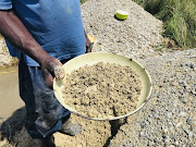 A group of brothers and their friends are making a living collecting gold off a mine dump near Marievale.