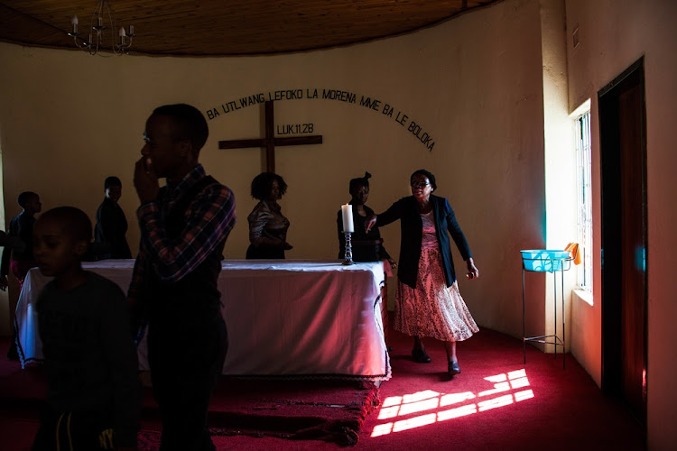 Members of the Presbyterian Church are seen during a Sunday Service inside Wonderkop, a settlement bordering Lonmin's Marikana mine on 16 August.