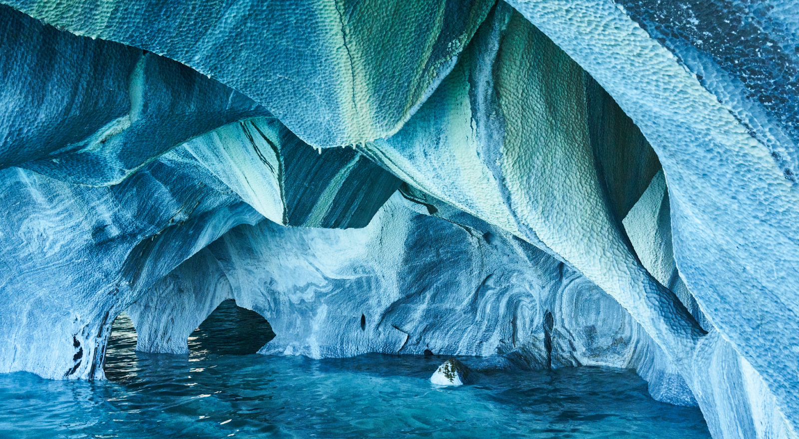 A to Z Bucket List - photo inside the Marble Caves of turquoise-colored cave walls and rippling water
