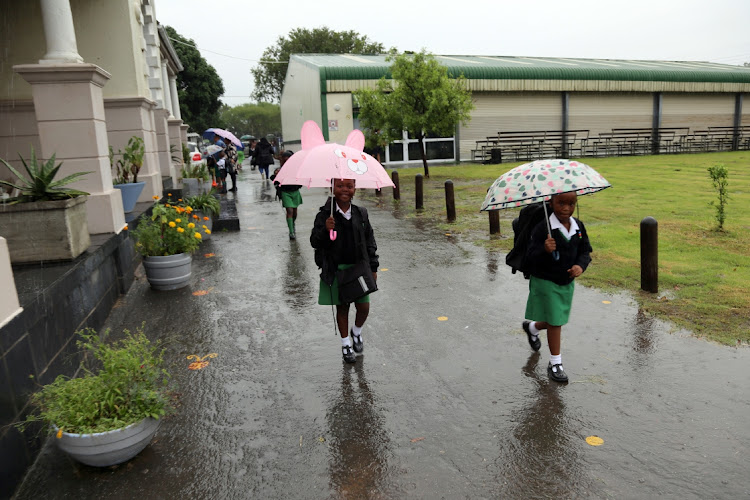 Cambridge Primary School children making their way to class, with their umbrellas, on the first day of school in East London yesterday.