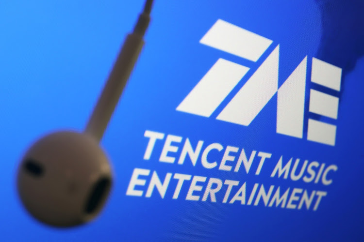 The logo of China's Tencent Music Entertainment Group is seen next to an earphone in this illustration picture taken March 22 2021. Picture: REUTERS/FLORENCE LO