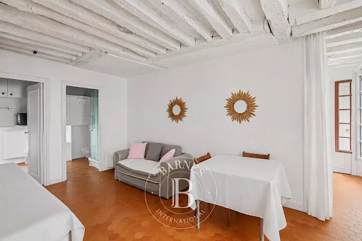 Luxury apartment / penthouse for sale in Paris 7ème (75007) - Neighborhood Gros Caillou - Living room with exposed beams and covered table