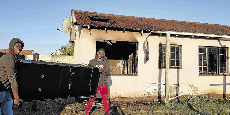 Residents of Finch Street in Gonubie move furniture after a fire gutted the residence yesterday afternoon.