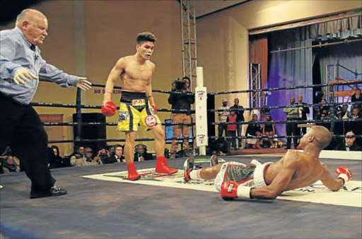 MAN DOWN: Apiwe Mboyiya is sent to the canvas by Jerry Castroverde from the Phillippines during their IBF Junior-lightweight Youth title fight at the Orient Theatre on Friday Picture: ALAN EASON