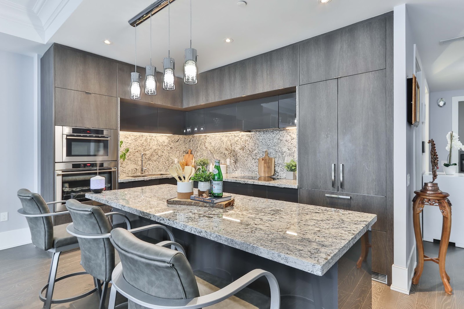 Kitchen with grey cabinets and grey marble countertops with all of the clutter removed in preparation for home staging.