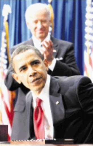 As Vice President Joe Biden applauds, President Barack Obama gets up from the table after signing the American Recovery and Reinvestment Act, Tuesday, Feb. 17, 2009, during a ceremony at the Denver Museum of Nature and Science in Denver. (AP Photo/Gerald Herbert)